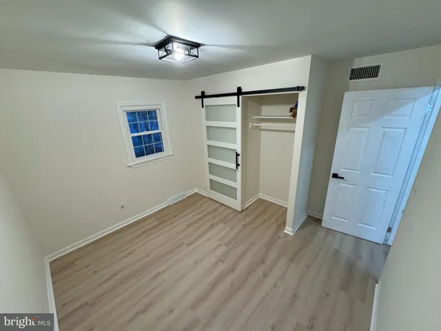 an empty room with wooden floor and closet