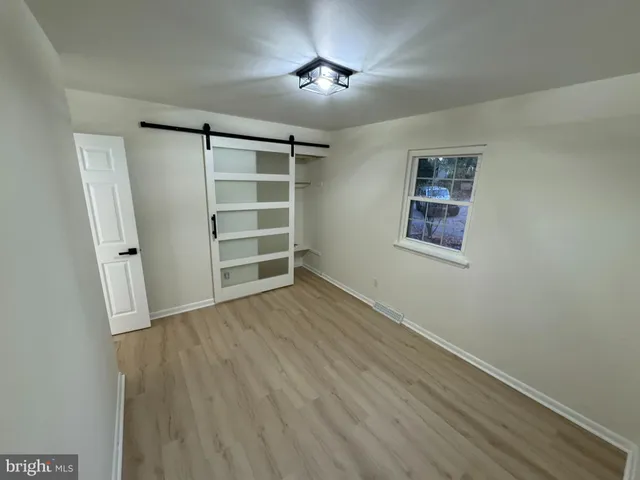 a view of room with a ceiling fan and wooden floor