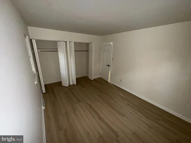 an empty room with wooden floor and closet