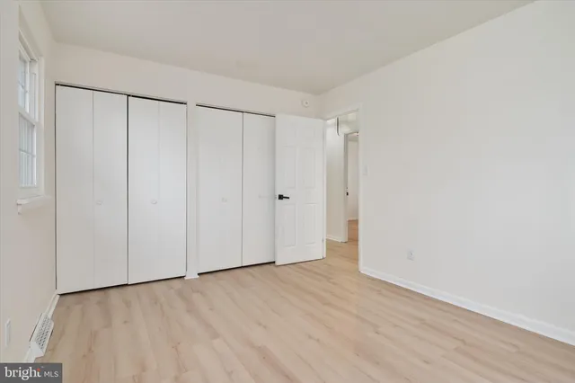 a view of an empty walk in closet with wooden floor