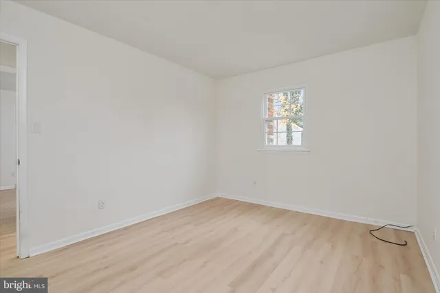 a view of an empty room with a fireplace and a window