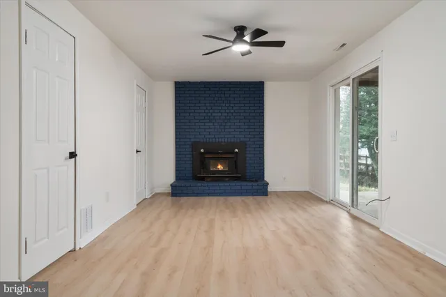 an empty room with a window and a ceiling fan