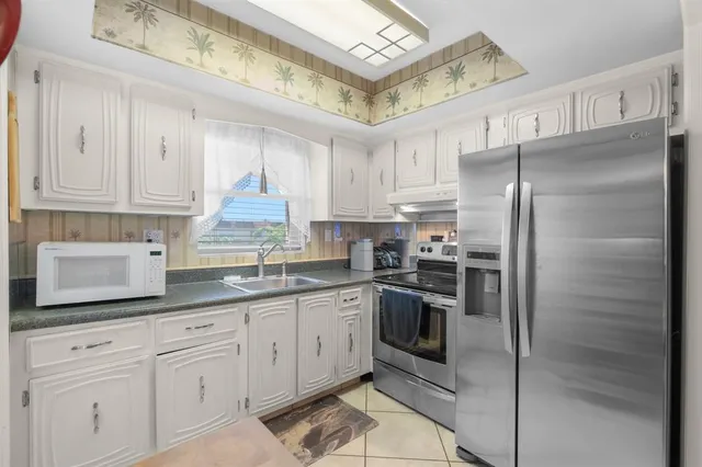 a kitchen with stainless steel appliances granite countertop a refrigerator sink and cabinets