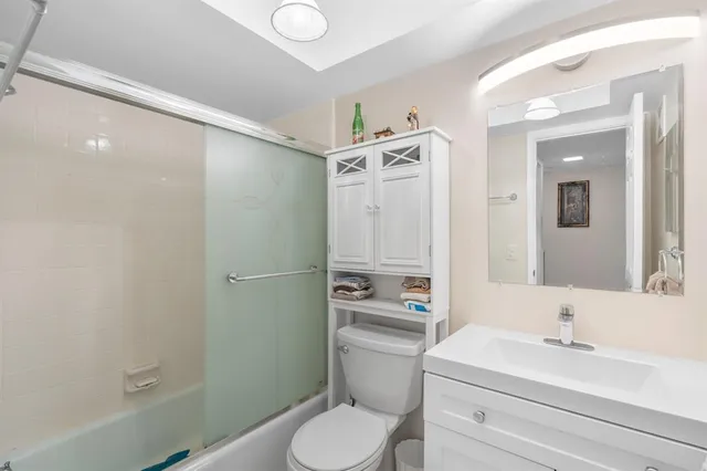 a bathroom with a sink toilet vanity and tub