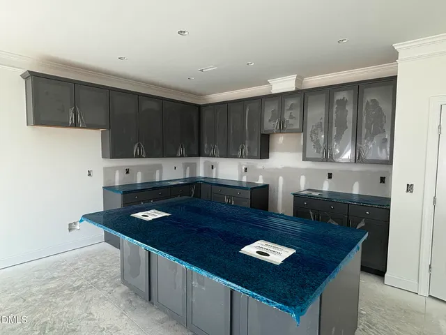 a kitchen with granite countertop stainless steel appliances a stove refrigerator sink and cabinets