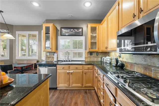 a kitchen with stainless steel appliances granite countertop a stove a sink and a microwave