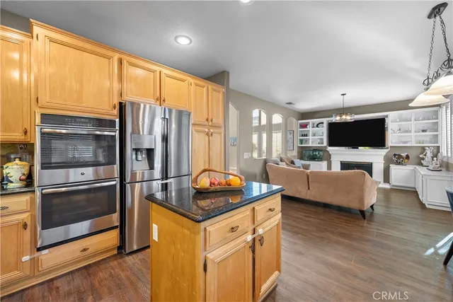 a kitchen with stainless steel appliances granite countertop a refrigerator a stove a sink and a refrigerator