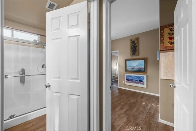a view of a hallway with front door and wooden floor