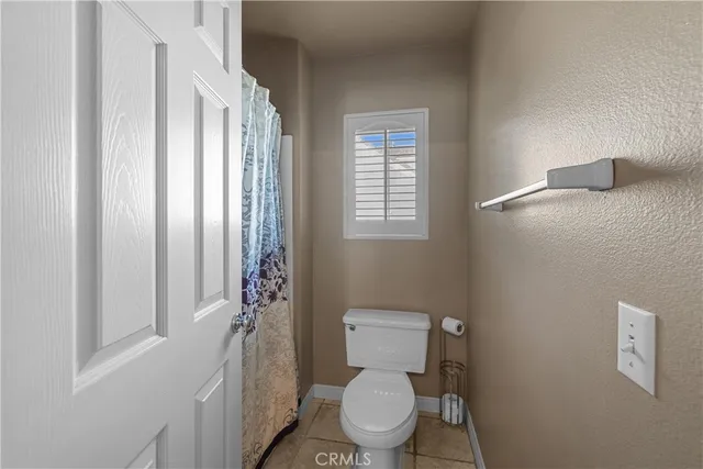 a bed sitting in a spacious bedroom next to a window