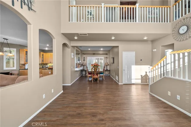 a living room with furniture and a dining table with wooden floor