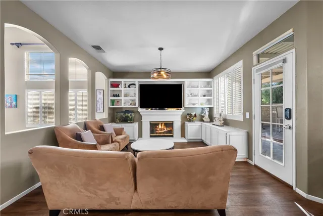 a living room with furniture a flat screen tv and a chandelier