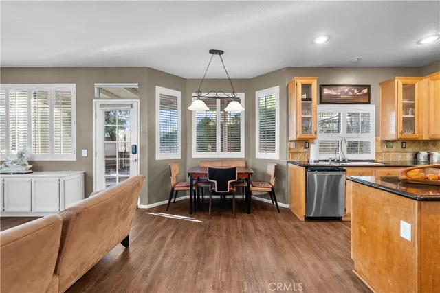 a dining room with wooden floor a chandelier a wooden table and chairs