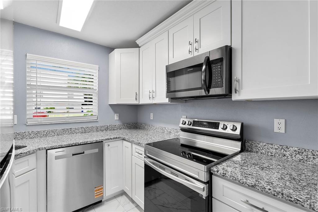 14929 Wise Way, Unit 931 Fort Myers, FL 33905 - Photo 18 of 39 a kitchen with stainless steel appliances granite countertop white cabinets granite counter tops and a stove