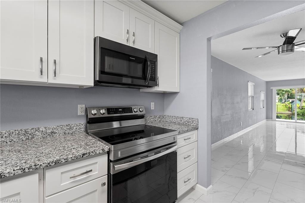 14929 Wise Way, Unit 931 Fort Myers, FL 33905 - Photo 19 of 39 a kitchen with granite countertop white cabinets stainless steel appliances and a counter space