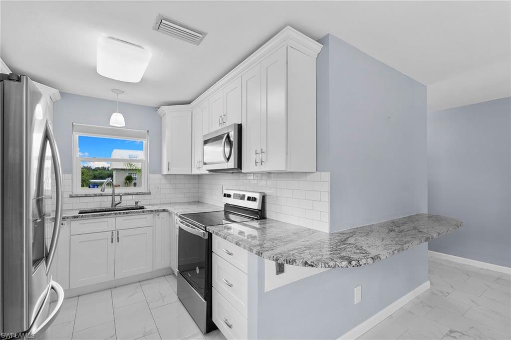 14929 Wise Way, Unit 931 Fort Myers, FL 33905 - Photo 5 of 39 a kitchen with a sink stove and refrigerator