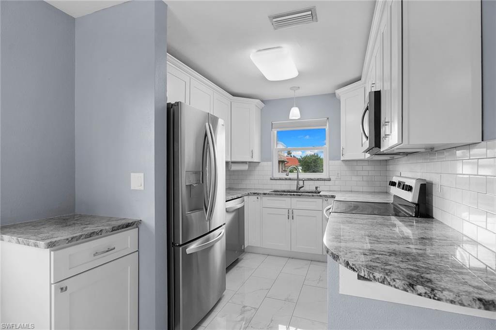 14929 Wise Way, Unit 931 Fort Myers, FL 33905 - Photo 6 of 39 a kitchen with a refrigerator stove top oven and sink