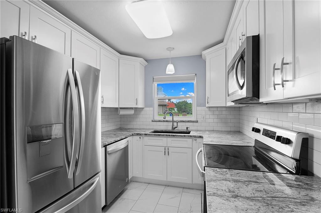14929 Wise Way, Unit 931 Fort Myers, FL 33905 - Photo 7 of 39 a kitchen with cabinets stainless steel appliances and a counter space