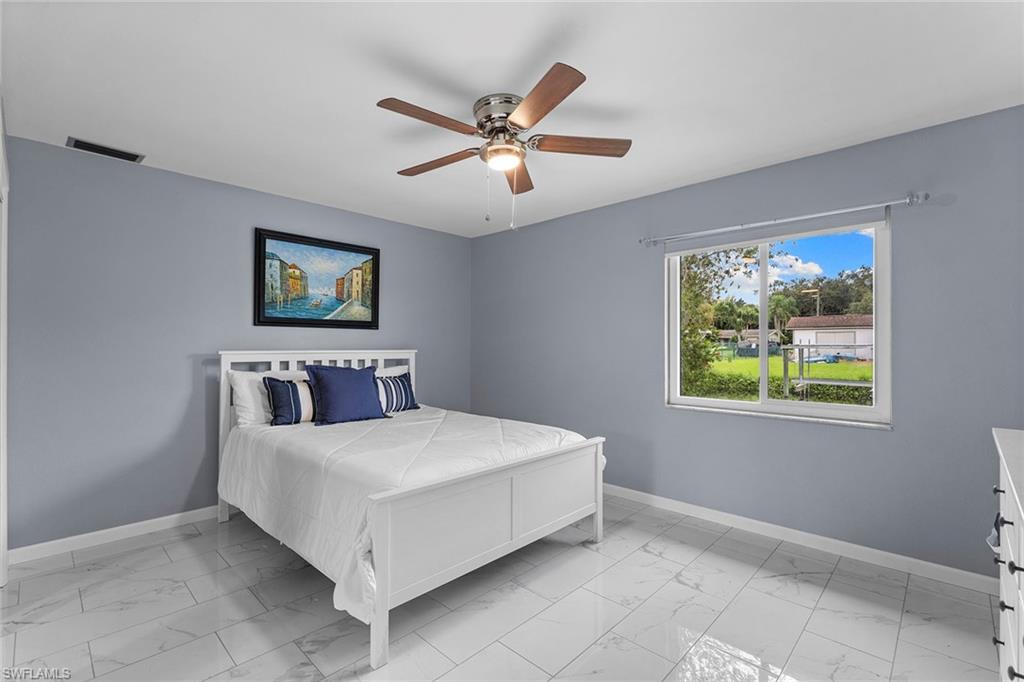 14929 Wise Way, Unit 931 Fort Myers, FL 33905 - Photo 10 of 39 a bedroom with a bed and a chandelier