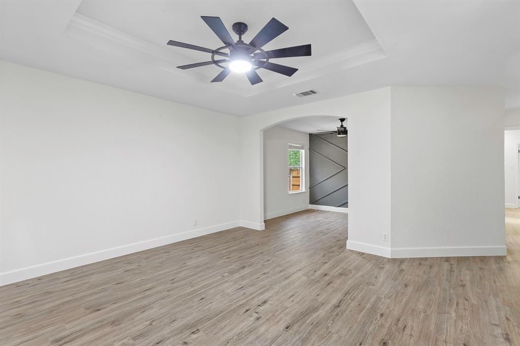 617 Barbara Way Bastrop, TX 78602 - Photo 6 of 20 Elegant tray ceiling in this spacious room, featuring durable vinyl plank flooring and contemporary ceiling fan lighting.