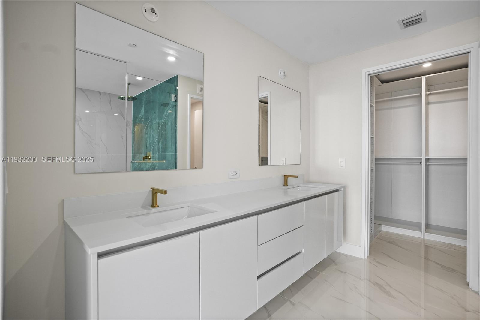 700 Northeast 24th Street, Unit 602 Miami, FL 33137 - Photo 31 of 39 a bathroom with a double vanity sink and a mirror