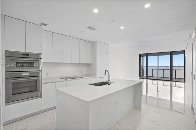 a kitchen with a sink stainless steel appliances and cabinets