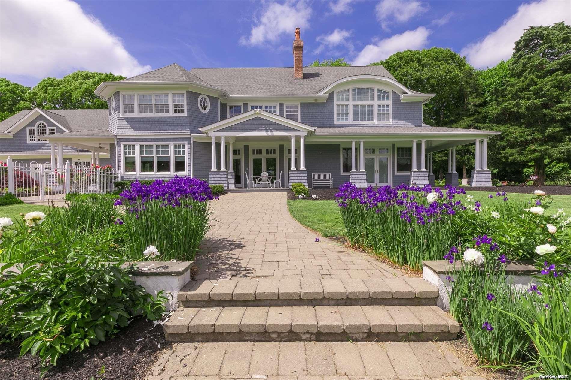 a front view of a house with a yard and potted plants