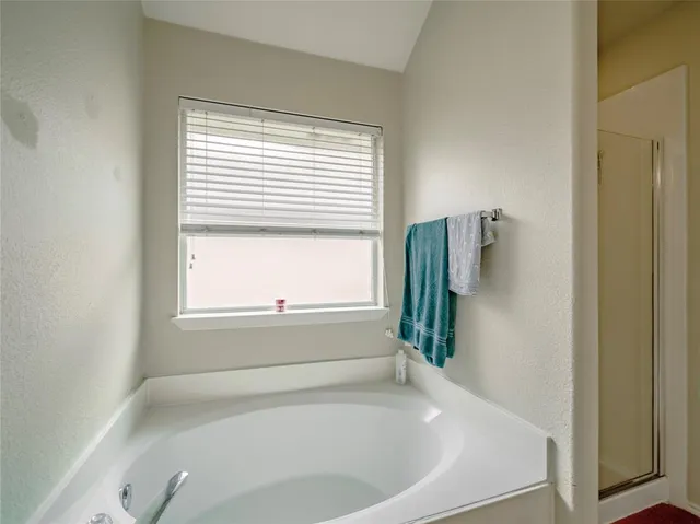 a white bath tub sitting in a bathroom next to a window