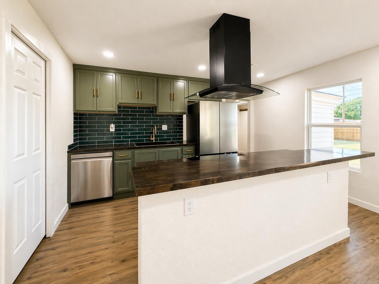 2316 48th Street Lubbock, TX 79412 - Photo 5 of 18 a large kitchen with stainless steel appliances a large counter top a stove and a refrigerator