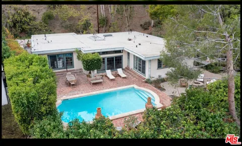 an aerial view of a house with swimming pool garden and patio