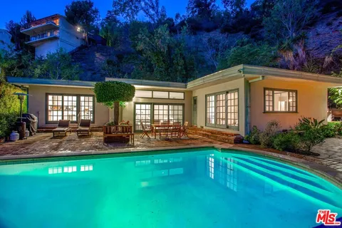 a front view of a house with patio and garden