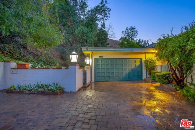 a view of a house with a yard and potted plants