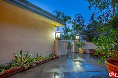 a backyard of a house with plants and outdoor seating