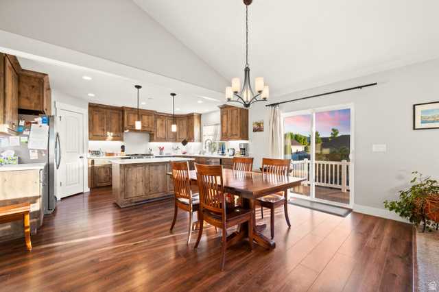 1145 North Christley Lane, Unit 48 Elk Ridge, UT 84651 - Photo 2 of 38 Open-concept kitchen and dining area featuring wood-finish flooring, vaulted ceilings, and a sliding glass door to an exterior deck