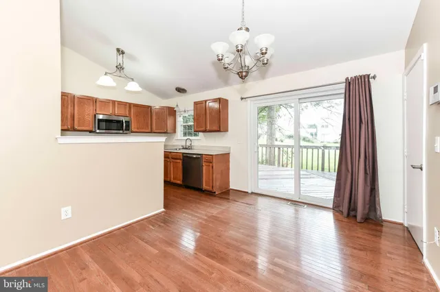 a living room with stainless steel appliances kitchen island granite countertop furniture and a large window