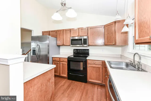 a kitchen with a sink a microwave a stove and refrigerator