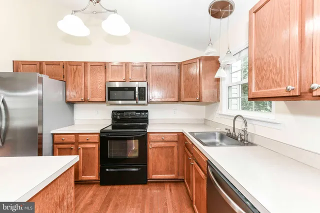 a kitchen with stainless steel appliances a sink stove and microwave
