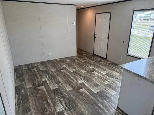 a view of a room with wooden floor and mirror