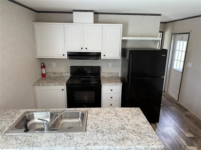 a kitchen with a refrigerator and a stove