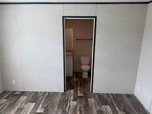 a view of a room with wooden floor and a bathroom
