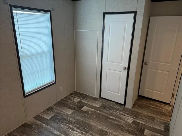 a view of a small space with wooden floor and a window