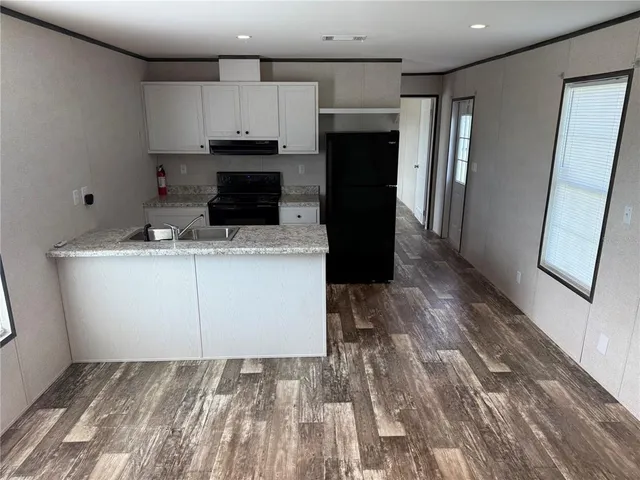 a kitchen with a sink a microwave a refrigerator and cabinets