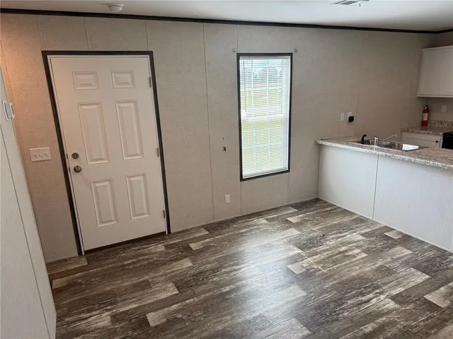 a view of empty room with window and wooden floor