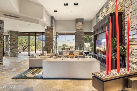 a living room with furniture a fireplace and a large window