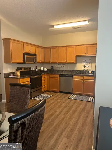 a kitchen with stainless steel appliances granite countertop a stove a sink and a microwave