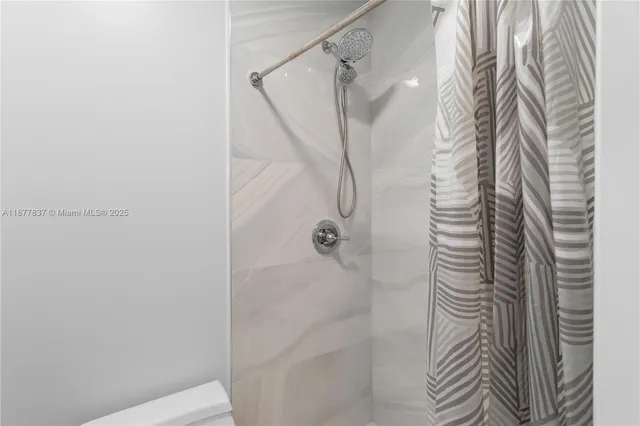 a bathroom with a shower and a shower curtain