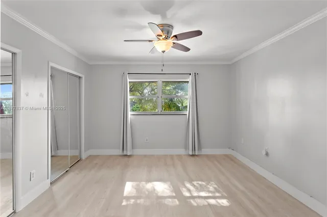 an empty room with fan and windows