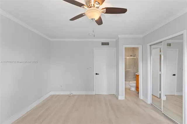 an empty room with closet and a chandelier fan