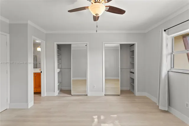 a view of a room with a ceiling fan and entryway