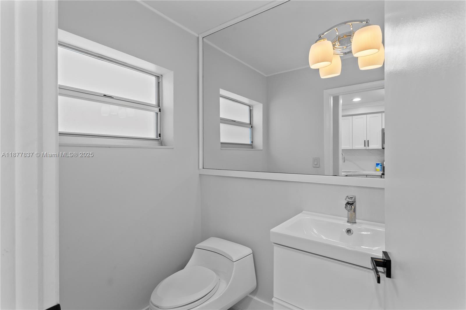 8600 Southwest 67th Avenue, Unit 937 Pinecrest, FL 33156 - Photo 18 of 24 a bathroom with a toilet sink vanity and mirror