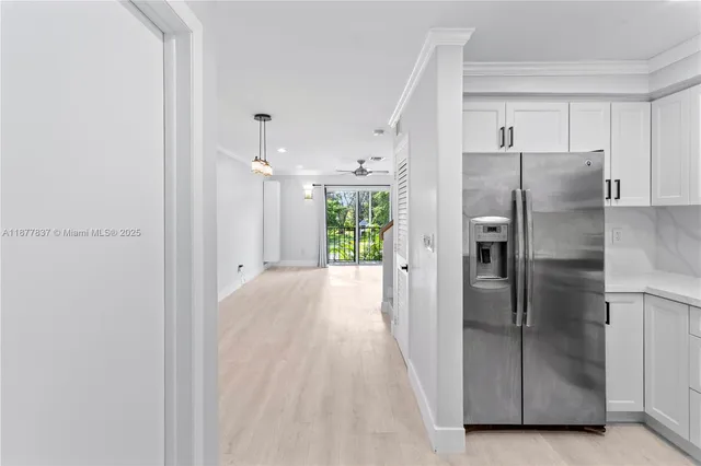 a view of a kitchen with a refrigerator wooden cabinets and a refrigerator
